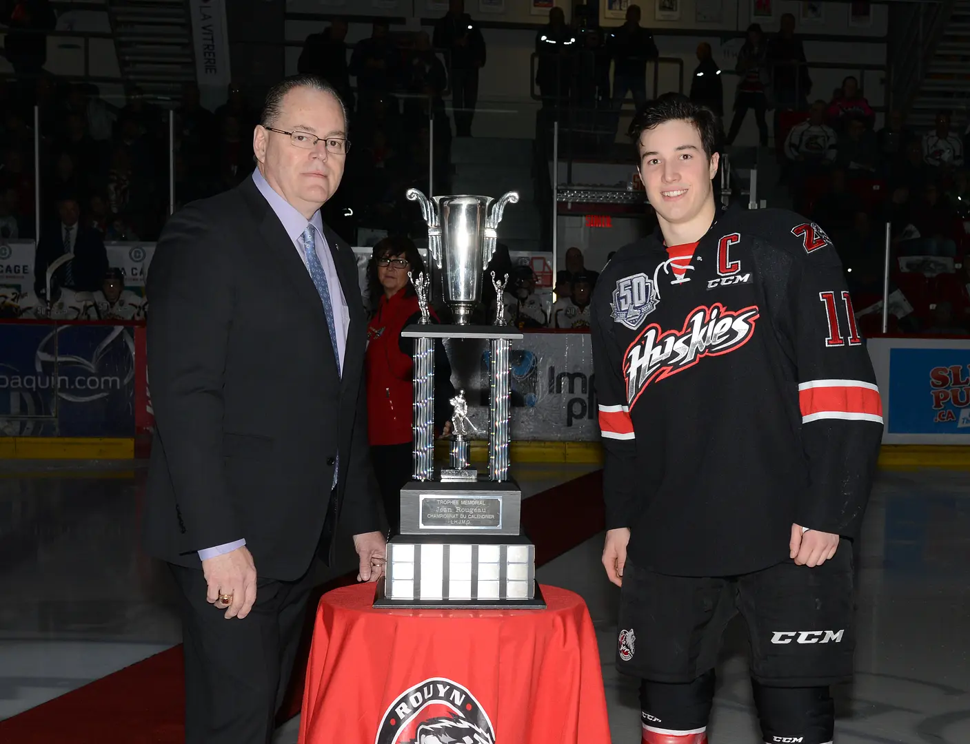 In 2018-19, the Huskies set a new QMJHL record with 59 wins, also tying the Sorel Eperviers' mark of 25 straight wins. They were presented with the Jean-Rougeau Trophy for their regular season championship. Captain Rafaël Harvey-Pinard proudly poses with the League's Director of Hockey Operations, Mr. Pierre Leduc.