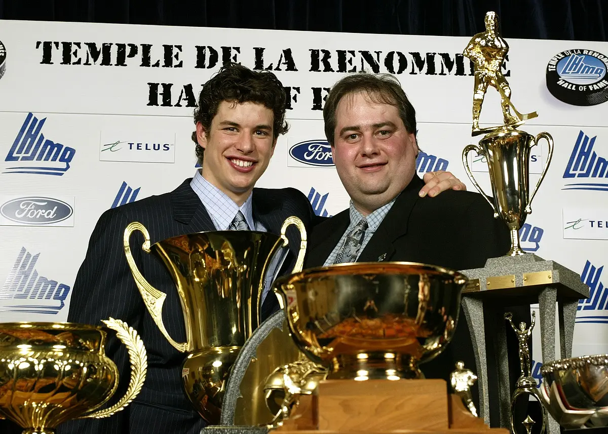 In 2004, Sidney Crosby poses in front of his trophies at the Golden Puck Gala, accompanied by Yannick Dumais, his faithful off-ice protector, and great manager of all the media aspects surrounding "Sid the Kid"...